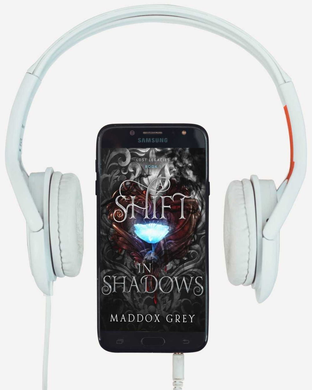 Phone with 'Shift in Shadows' book cover displayed, flanked by white headphones on a white background