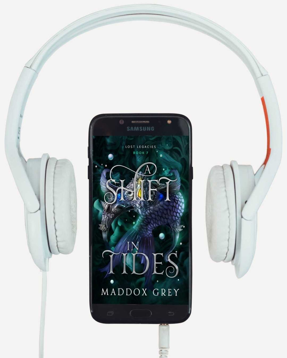 Samsung phone displaying a book cover with dragon imagery, flanked by white headphones.